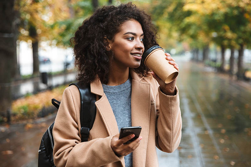 Woman walking down the street drinking coffee